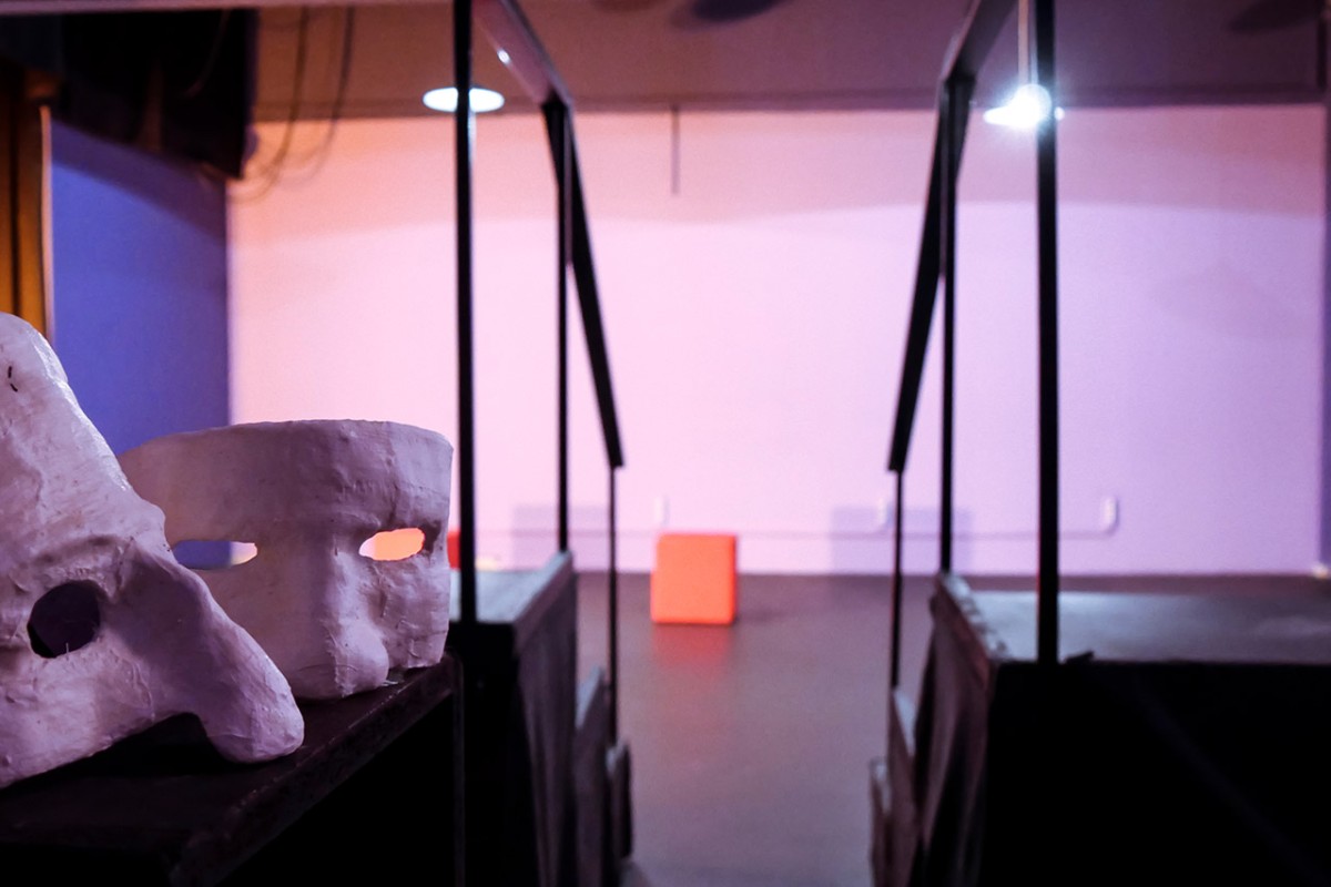 Δύο προσωπεία με φόντο τη σκηνή του Action Theater