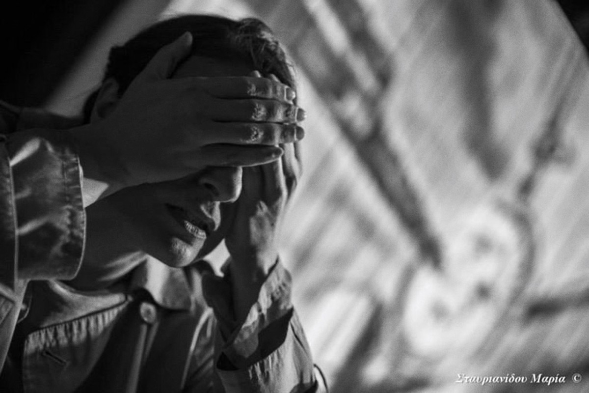 Μία γυναίκα καλύπτει τα μάτια της